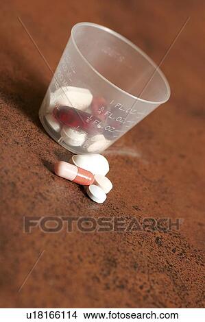 Pills and a medicine cup View Large Photo Image Picture - Pills and a medicine cup. Fotosearch