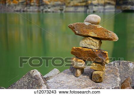 Stock Image - Rock art figure at waters edge. Fotosearch