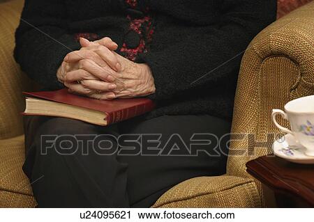 Stock Image - Senior woman in prayer. Fotosearch