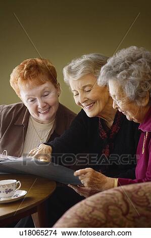 Sharing memories through a photo album View Large Photo Image Picture - Sharing memories through a photo album. Fotosearch
