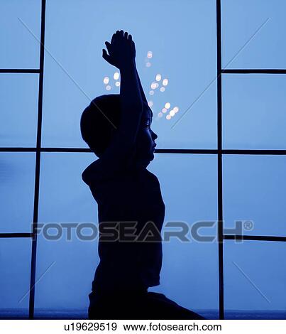 Stock Photo - Silhouette of small boy in window. Fotosearch
