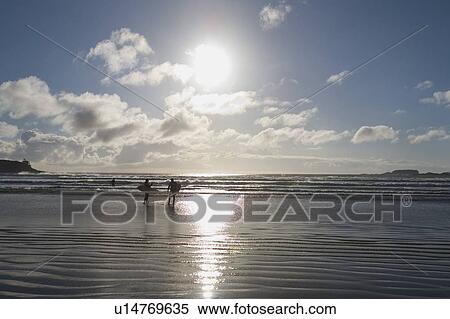 Surfers on a beach View Large Photo Image Stock Photography - Surfers on a beach. Fotosearch