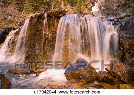 Waterfall flowing over rugged terrain View Large Photo Image Picture - Waterfall flowing over rugged terrain. Fotosearch