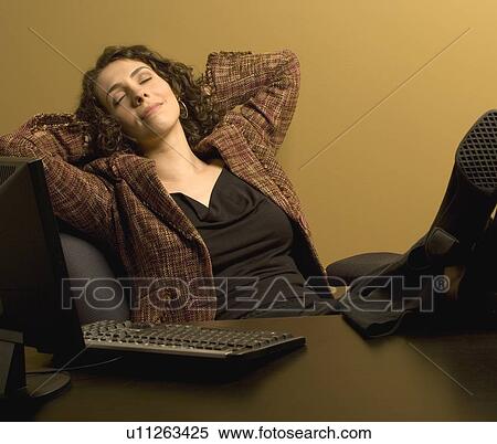 Stock Photography - Woman resting at her desk. Fotosearch