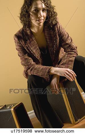 Woman sitting on suitcase View Large Photo Image Stock Photo - Woman sitting on suitcase. Fotosearch