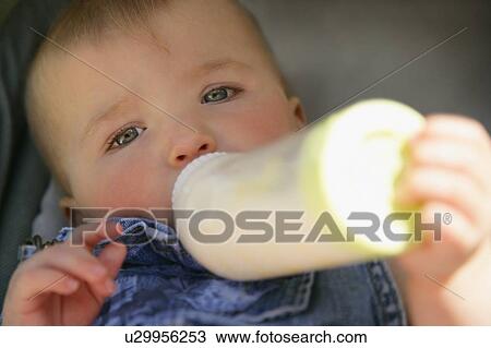 Stock Image - Baby feeding from bottle. Fotosearch