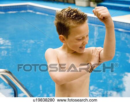 Stock Image - Boy examines his bicep. Fotosearch