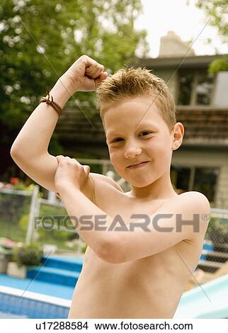 Boy feeling his bicep View Large Photo Image Picture - Boy feeling his bicep. Fotosearch