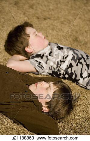 Boys laying on the ground View Large Photo Image Stock Image - Boys laying on the ground. Fotosearch