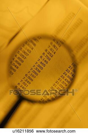 Stock Photograph - Magnifying glass looking at rates. Fotosearch