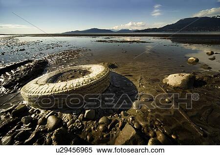 Stock Photography - Old tire on beach. Fotosearch