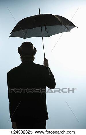 Stock Photography - Person under umbrella. Fotosearch
