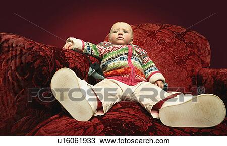 A child sits on a sofa View Large Photo Image Stock Image - A child sits on a sofa. Fotosearch