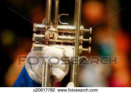 Stock Image - A gloved hand holds a trumpet. Fotosearch