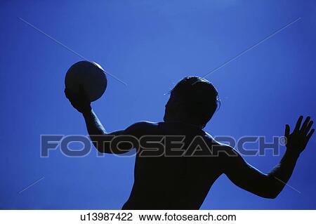 Stock Image - A man serving a volleyball. Fotosearch