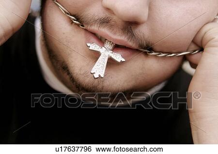 Stock Photograph - A man with necklace in his mouth. Fotosearch