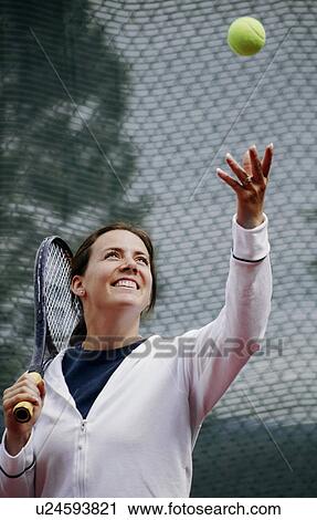 Stock Image - A woman playing tennis. Fotosearch