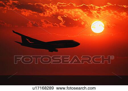 Airplane flying during sunrise/sunset View Large Photo Image Stock Photo - Airplane flying during sunrise/sunset. Fotosearch