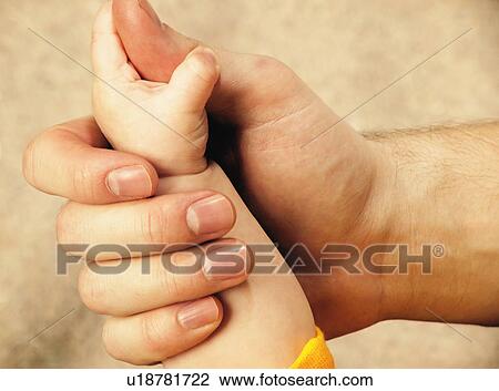 Stock Image - Baby's hand holds on. Fotosearch