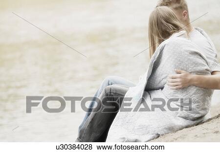 Blanket wrapped around couple on beach View Large Photo Image Stock Photo - Blanket wrapped around couple on beach. Fotosearch