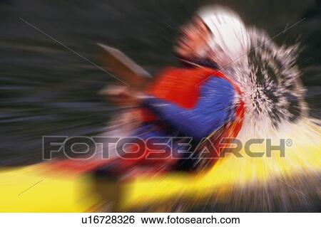 Stock Photograph - Blurred image of man in yellow kayak. Fotosearch