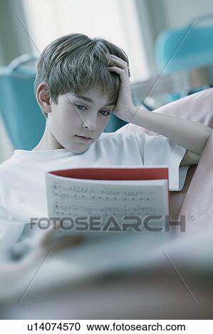 Boy reading a music book View Large Photo Image Stock Image - Boy reading a music book. Fotosearch
