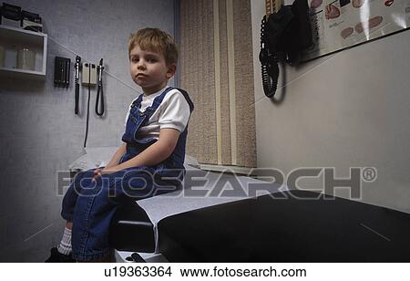 Picture - Boy sitting on table in doctor's office. Fotosearch