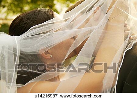 Stock Photo - Bride and groom kiss. Fotosearch