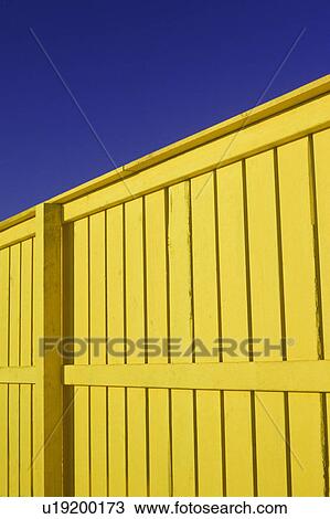 Bright yellow wood fence with deep blue sky View Large Photo Image Stock Image - Bright yellow wood fence with deep blue sky. Fotosearch