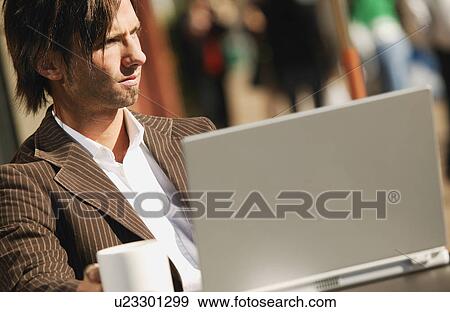Businessman sitting at computer with coffee View Large Photo Image Stock Photo - Businessman sitting at computer with coffee. Fotosearch