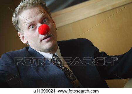 Stock Image - Businessman wearing red nose. Fotosearch