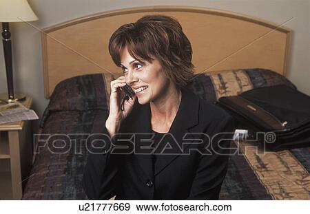 Businesswoman talking on the phone in hotel bedroom View Large Photo Image Stock Photo - Businesswoman talking on the phone in hotel bedroom. Fotosearch