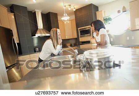 Stock Photo - Chatting in the kitchen. Fotosearch