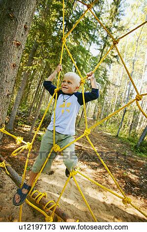 Stock Image - Child climbing ropes. Fotosearch