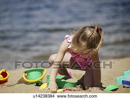 Child playing in the sand View Large Photo Image Picture - Child playing in the sand. Fotosearch