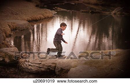 Child plays by water View Large Photo Image Stock Photo - Child plays by water. Fotosearch