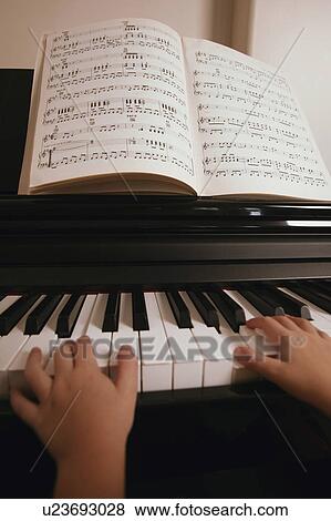 Stock Photo - Child plays the piano. Fotosearch