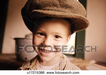 Child tries on a large hat View Large Photo Image Stock Photograph - Child tries on a large hat. Fotosearch