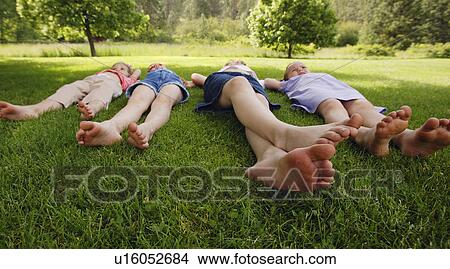 Children laying on the grass View Large Photo Image Picture - Children laying on the grass. Fotosearch