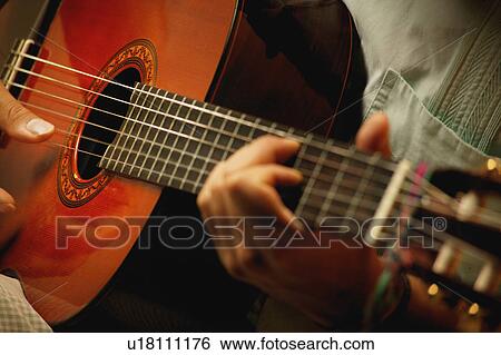 Closeup of a guitar being played View Large Photo Image Stock Photograph - Closeup of a guitar being played. Fotosearch