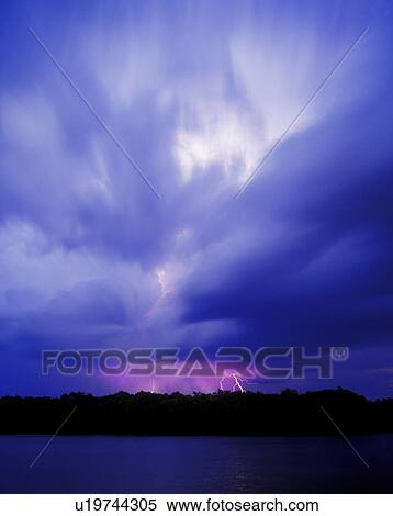 Stock Photography - Cloudy sky with lightning in the distance. Fotosearch