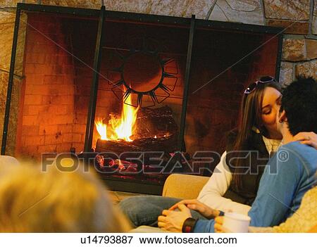 Couple kiss in front of fireplace View Large Photo Image Stock Photo - Couple kiss in front of fireplace. Fotosearch
