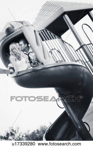 Stock Image - Couple kiss on a slide. Fotosearch