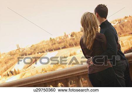 Stock Image - Couple look out over city. Fotosearch