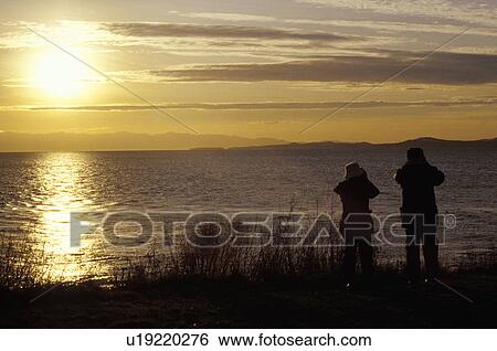 Couple looking over water View Large Photo Image Stock Photograph - Couple looking over water. Fotosearch