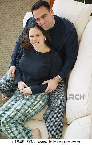 Couple snuggles on sofa View Large Photo Image Stock Photo - Couple snuggles on sofa. Fotosearch