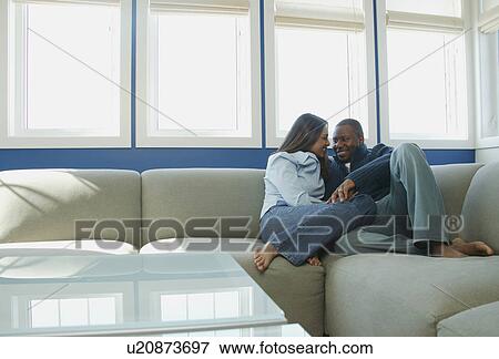 Couple snuggles on sofa View Large Photo Image Stock Photo - Couple snuggles on sofa. Fotosearch