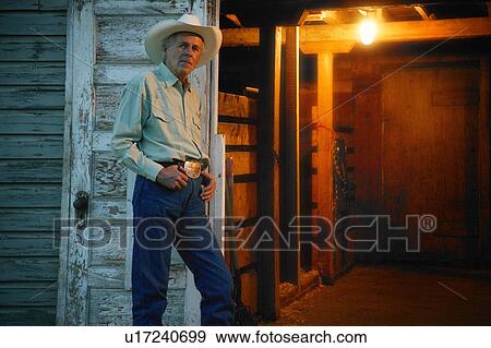 Stock Photo - Cowboy stands by door. Fotosearch
