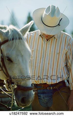 Stock Image - Cowboy with his horse. Fotosearch