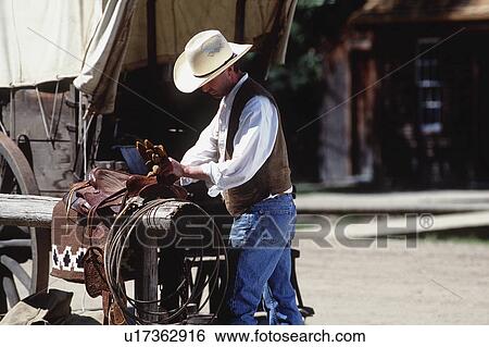 Cowboy working on saddle View Large Photo Image Stock Photograph - Cowboy working on saddle. Fotosearch